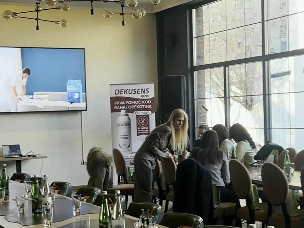 Prezentacija na ekranu od 98 inča, publika za stolovima