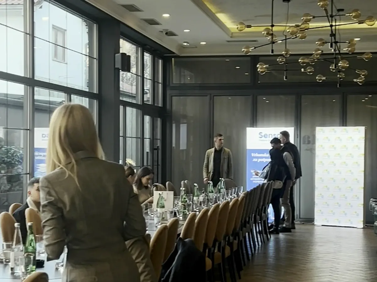 Predavač uz dugi sto, dnevno svetlo